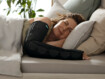 Eine Frau liegt im Bett und trägt am Arm den Juzo SleepCompress