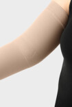 Mulher usando manga de compressão Juzo com a zona funcional para o cotovelo
