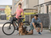 Een vrouw en een man laten met een fiets een hond uit