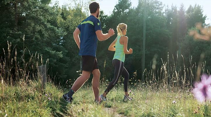Smärtor i fotleden En man och en kvinna som joggar