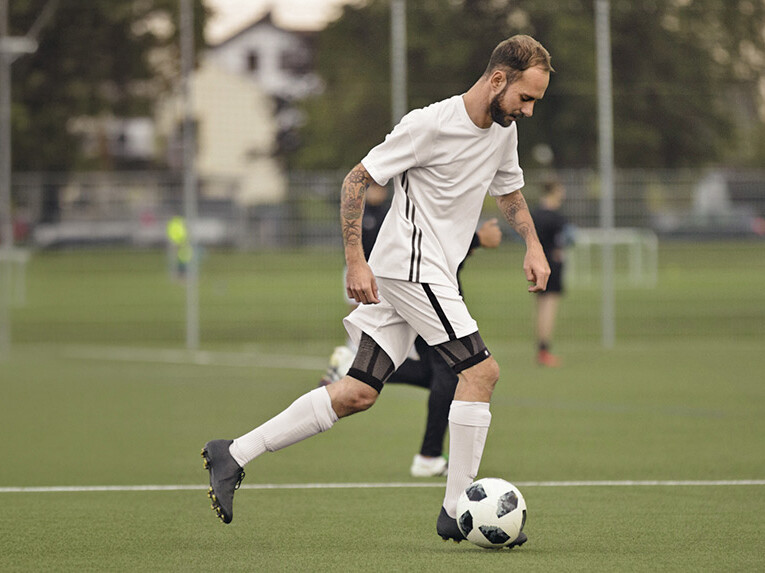 Ein Fußballer führt einen Fußball