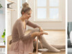 Frau im Ballerinaoutfit mit Juzo Expert mit Funktionszone Rist sitzt auf dem Boden und zieht sich Spitzenschuhe an