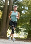 Mulher a fazer jogging a usar a ortótese para joelhos JuzoPro Patella Xtec Plus